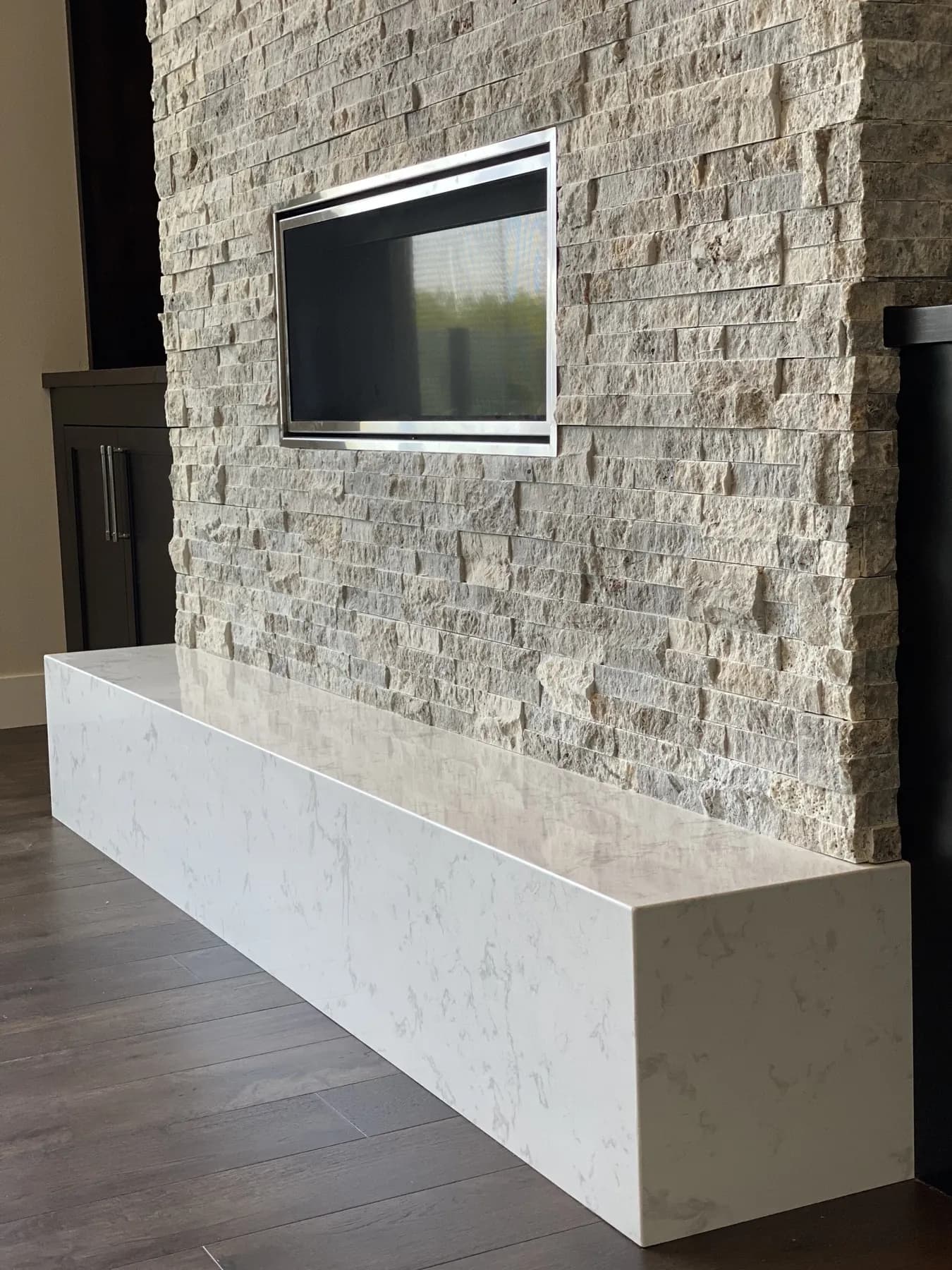 Stone & quartz hearth: Stacked ledgestone meeting a floating quartz bench.